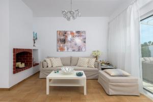 a living room with a couch and a table at Casa Bianca Villa in Kolimbia