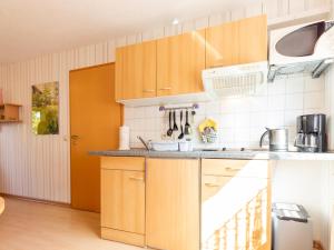 a kitchen with wooden cabinets and a counter top at Ferienwohnung Schwarz in Gademow