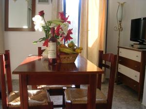 einen Tisch mit einer Flasche Wein und einem Obstkorb in der Unterkunft Stefanos Apartments in Agia Fotia