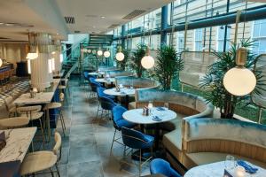 a restaurant with tables and chairs and windows at Le Monde Hotel in Edinburgh