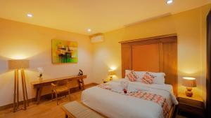 a bedroom with a bed and a desk in it at Shitala Villa in Munduk