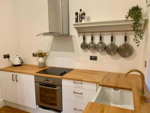 a kitchen with a counter with pots and pans on the wall at Flat 2 Struan house in Pitlochry +3 photos