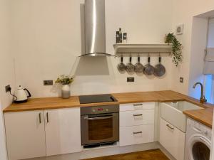a kitchen with white cabinets and a stove top oven at Flat 2 Struan house in Pitlochry