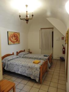 a bedroom with two beds and a chandelier at B&B Goriano Valli in Goriano Valli