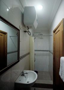 a bathroom with a sink and a shower and a toilet at Nspri Guest Houses in Lagos