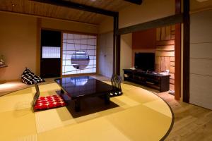 城崎温泉 但馬屋-Tajimaya- في تويوكا: غرفة معيشة مع طاولة وتلفزيون
