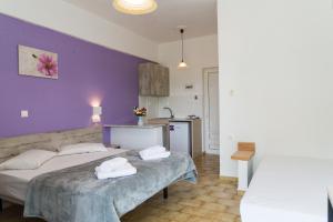 una camera da letto con due letti e una parete viola di Laganas Dreams 1 a Laganas