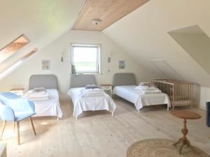 a attic room with two beds and a window at Brunbjerg Apartments in Billund