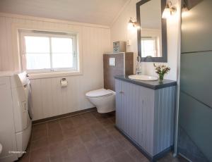 La salle de bains est pourvue d'un lavabo, de toilettes et d'un miroir. dans l'établissement Kirkvollen pilegrimsgård, à Tydal