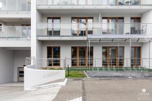 zewnętrzny widok na biały budynek z balkonem w obiekcie DELUXE 38 Bałtycka 6 by Jantar Apartamenty Kołobrzeg w Kołobrzegu