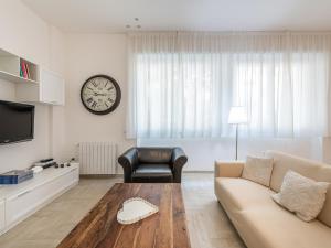 a living room with a couch and a clock on the wall at Casa BEAR - City Centre in Cagliari