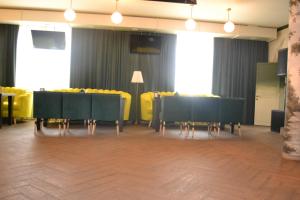 a dining room with black tables and yellow chairs at Ayhan Hotel in Aktobe