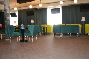 a dining room with a table and green chairs at Ayhan Hotel in Aktobe