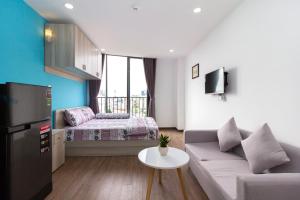 una pequeña sala de estar con sofá y cama en The Art - Tina Hotel and Apartments en Ho Chi Minh