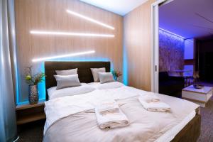 - une chambre avec un grand lit et 2 serviettes dans l'établissement Apartment Luna Hrebienok C108, à Starý Smokovec