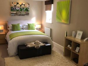 a bedroom with a bed with a stuffed animal on a ottoman at Keepers Lodge in Swithland