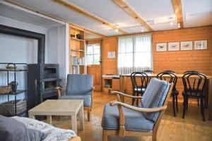 a living room with a couch and chairs and a table at Traditionelles Chalet Schärmtanne in Aeschi