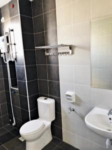 a bathroom with a toilet and a sink at Desaru Cosy Homestay - near WaterPark, Beach, Rapid -Wifi, TVbox, Steamboat, BBQ Available in Desaru