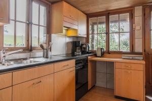 a kitchen with a sink and a stove top oven at Traditionelles Chalet Schärmtanne in Aeschi