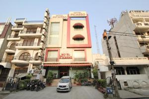 新德里的住宿－Hotel Picasso Paschim Vihar Delhi - Couple Friendly Local IDs Accepted，停在大楼前的汽车