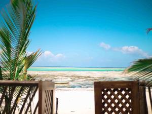 a view of the ocean from a beach with a chair at Hekaya Zanzibar in Pingwe