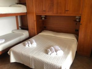 - 2 lits dans une chambre avec des serviettes blanches dans l'établissement Residence Le Palme - Appartamenti sul mare - Spiaggia tra Palinuro e Caprioli, à Pisciotta