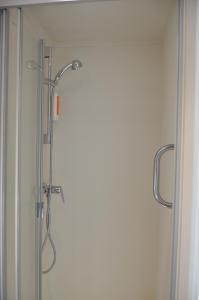 um chuveiro numa casa de banho com uma porta de vidro em easyHotel Zürich West em Zurique