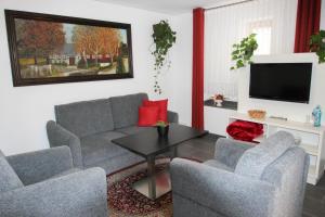 uma sala de estar com um sofá e duas cadeiras e uma mesa em Pension-Maustmühle em Peitz