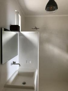 a white bathroom with a sink and a plane on the wall at Casa Isabella in Malfa +23 photos