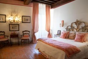 a bedroom with a large bed and a chandelier at Palazzo Malaspina B&B in Tavarnelle Val di Pesa