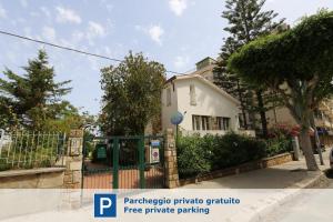 a white house with a fence in front of it at Lumachella B&B in Cefalù