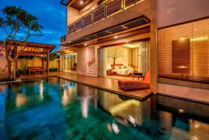 an indoor swimming pool in a home with a house at The Miracle Villa Nusa Dua in Nusa Dua
