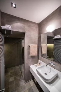 bagno con lavandino, doccia e specchio di Relais Metelli a Foligno