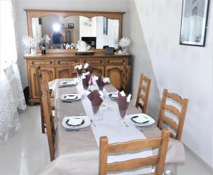 uma sala de jantar com uma mesa com cadeiras e um espelho em Chambre du Hamel em Avroult