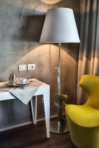 a lamp sitting next to a table with a yellow chair at Relais Metelli in Foligno