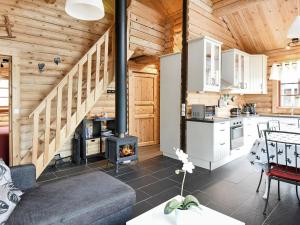 Cabaña de madera con cocina y sala de estar con chimenea. en Two-Bedroom Holiday home in Sälen 2, en Tandådalen