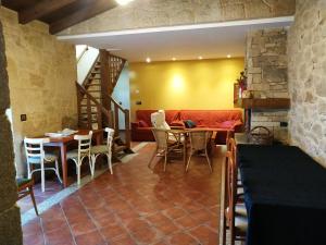 a living room with a couch and a table and chairs at Casa Rural La Veterinaria in Aldeadávila de la Ribera