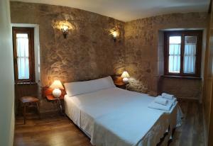 a bedroom with a bed with two lights on the wall at Casa Rural La Veterinaria in Aldeadávila de la Ribera