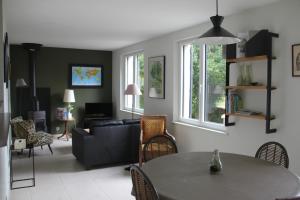 uma sala de estar com uma mesa e um sofá em La Bellevue, maison entière em Hénouville