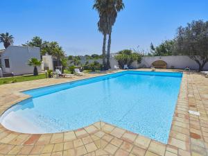 a large swimming pool with blue water in a yard at Lush Villa with Private Swimming Pool in Marsala Sicily in Marsala
