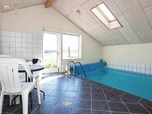 a swimming pool with a table and chairs in a room at 10 person holiday home in Harbo re in Harboør