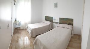 
a bedroom with two beds and a desk at Hotel La Lancha in Córdoba
