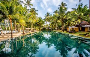 uma piscina no resort com palmeiras e guarda-sóis em Peninsula Beach Resort em Ko Chang