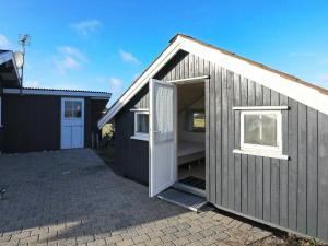 a small house with a door and a garage at 8 person holiday home in Harbo re in Harboør