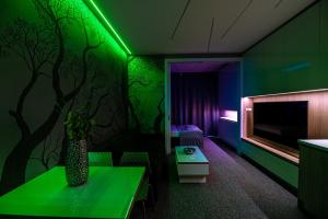 een groene kamer met een tafel en een tv bij Apartment Luna Hrebienok D2 in Stary Smokovec