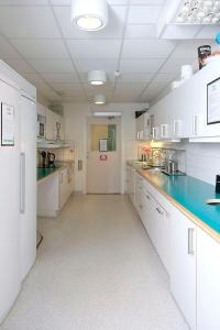 a large kitchen with white cabinets and blue counter tops at Citysleep in Luleå