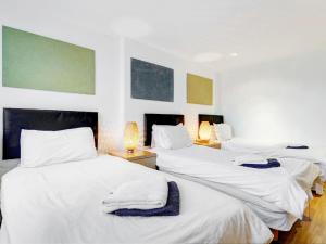 a hotel room with two beds and two lamps at Acorn - Bedford Place Apartments in London