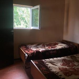 a bedroom with two beds and a window at Guest House Malkhaz Niguriani in Zhabeshi