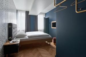 a bedroom with a bed and a desk at Hotel MIO by AMANO in Munich
