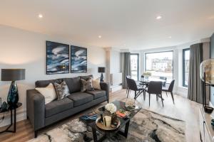 a living room with a couch and a table at The Carlyle - Stunning Serviced Apartments in London